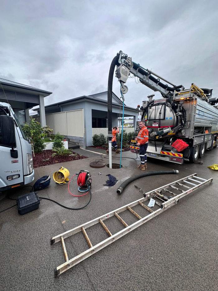 A woman wearing construction clothes and talking on her phone